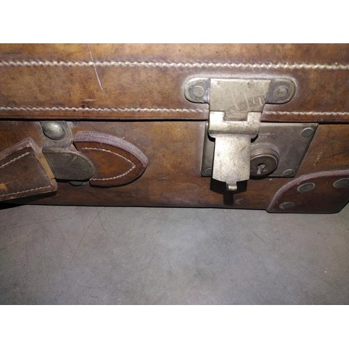 197 - A large early leather suitcase (missing brass plaque on lid)