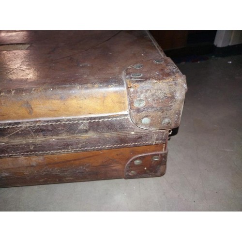 197 - A large early leather suitcase (missing brass plaque on lid)