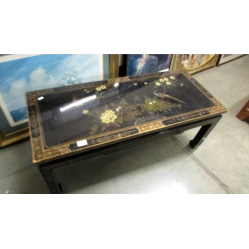 1707 - A black lacquered coffee table decorated with birds. COLLECT ONLY.