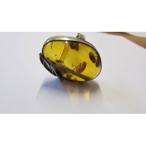 208 - A large silver ring with large amber coloured stone in art deco design.