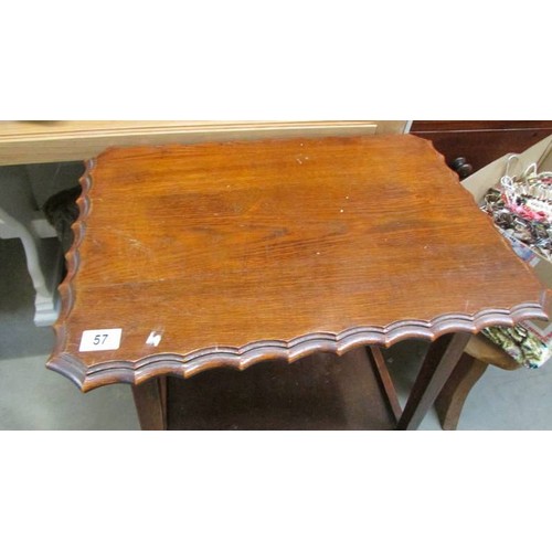 57 - A darkwood table with drawers and glass inset top.