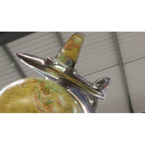 105 - A World globe featuring an air plane.