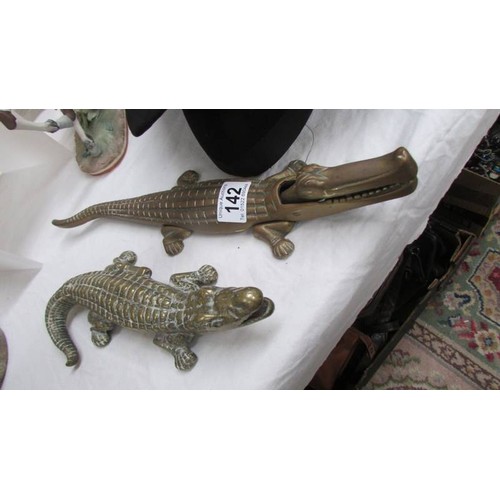 142 - Two brass crocodiles.