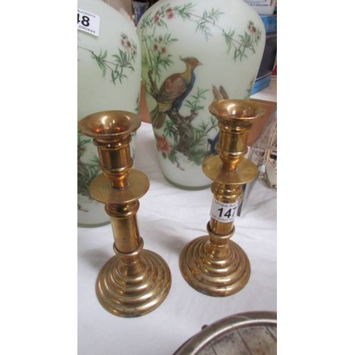 147 - A pair of brass candlesticks.