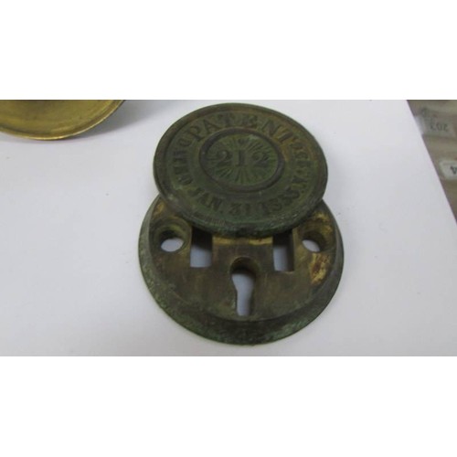 277 - A brass bell and two cast metal key covers.