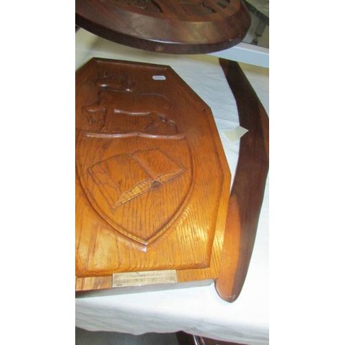 322 - Three carved wood plaques, a slate panel and a boomerang.