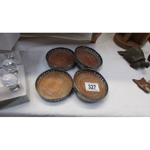 327 - A set of four silver plate wine coasters.