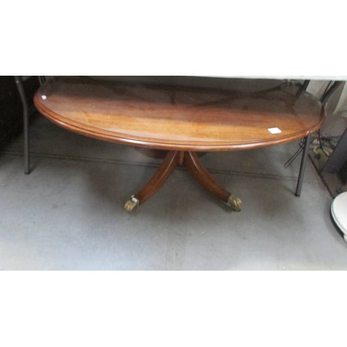 331 - An oval glass topped coffee table with brass lion paw feet, COLLECT ONLY.