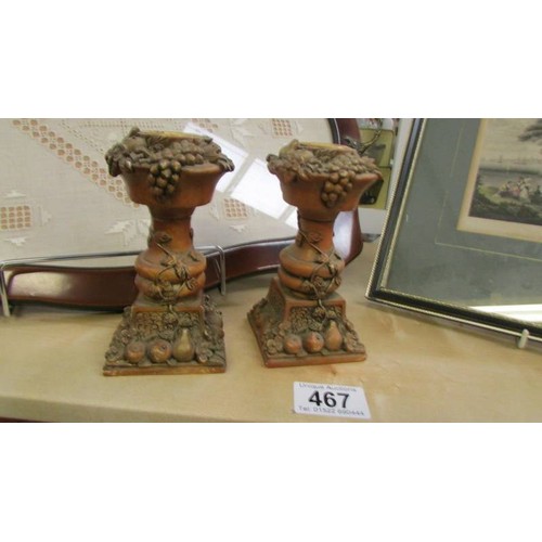 467 - A pair of fruit decorated candlesticks.