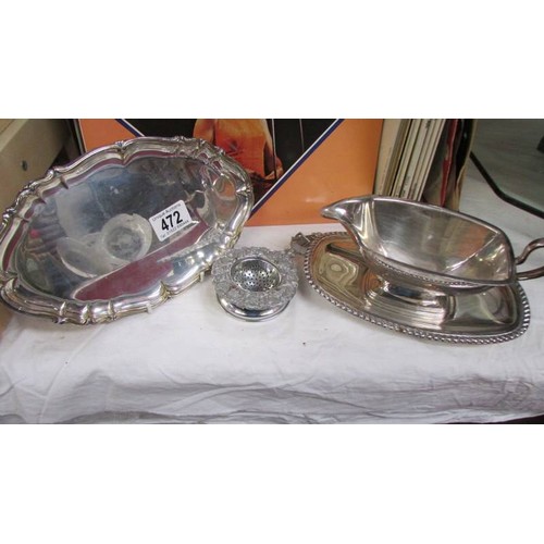 472 - A silver plate gravy boat on tray, another tray and a tea strainer.