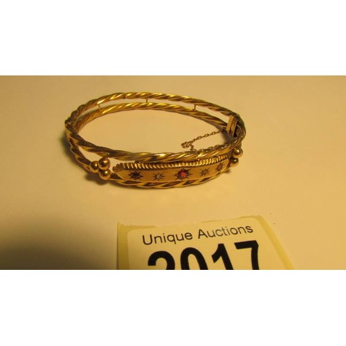 2017 - A 9ct gold bangle with safety chain, 9.3 grams.