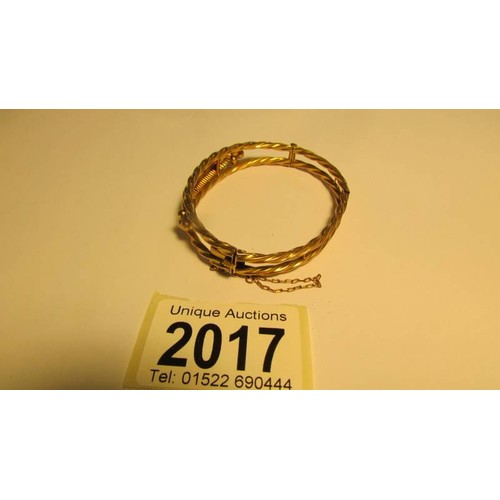 2017 - A 9ct gold bangle with safety chain, 9.3 grams.