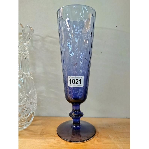 1021 - A heavy cut glass vase, 26 cm and a blue glass vase, 30 cm.  COLLECT ONLY.