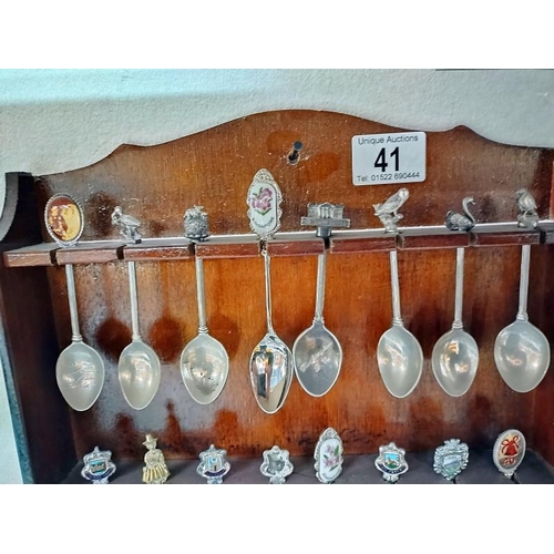 41 - A selection of tourist collectors spoons on rack