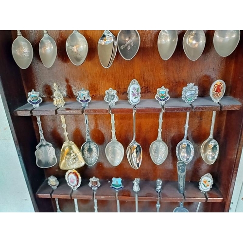 41 - A selection of tourist collectors spoons on rack