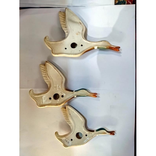 2136 - A set of 3 graduated pottery flying ducks wall ornaments embossed England on rear