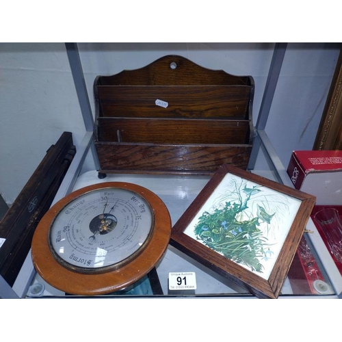 91 - An oak letter rack, selection of oak frames and a barometer