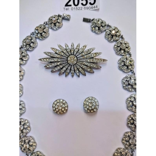 2055 - A vintage paste necklace, brooch and ear clips