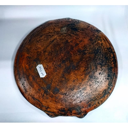 2195 - A shallow painted pottery plate with tribal design. 21cm diameter. 21.5cm top to bottom.