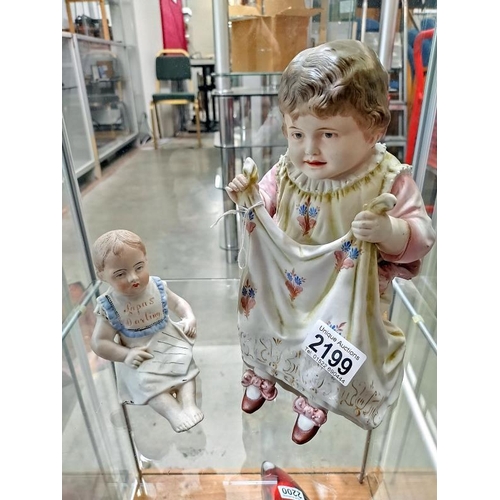 2199 - A Bisque porcelain figure of a small girl seated and another figure, 'Papa's Darling'.