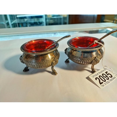 2095 - A pair of silver plate salts with Cranberry glass liners and two silver salt spoons