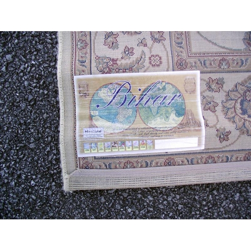 245 - A large beige patterned/ Persian rug. Length 2.28cm x 1.60cm, COLLECT ONLY.