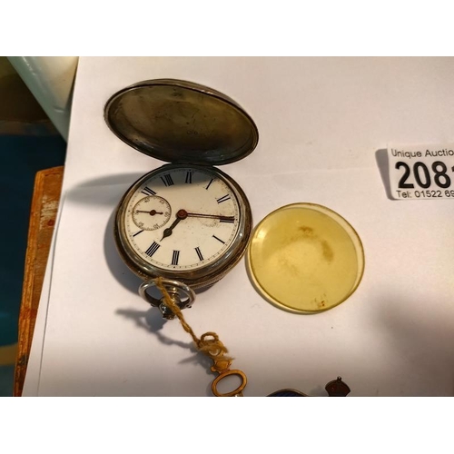 2081 - A silver hunter pocket watch A/F. A quantity of military cap badge including silver enamel RAF wings... 