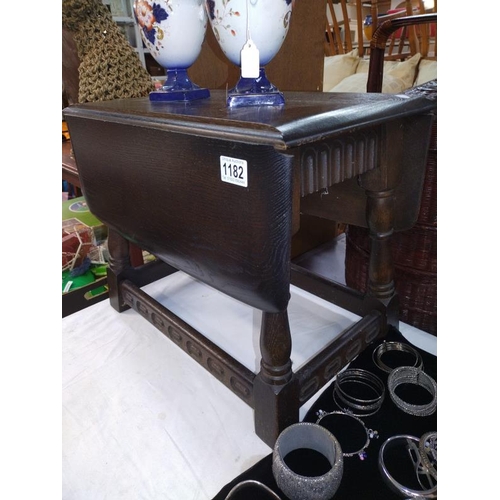 1182 - A small drop leaf swivel top dark oak tea table. 51cm x 32cm (68cm) x Height 41cm.  COLLECT ONLY.