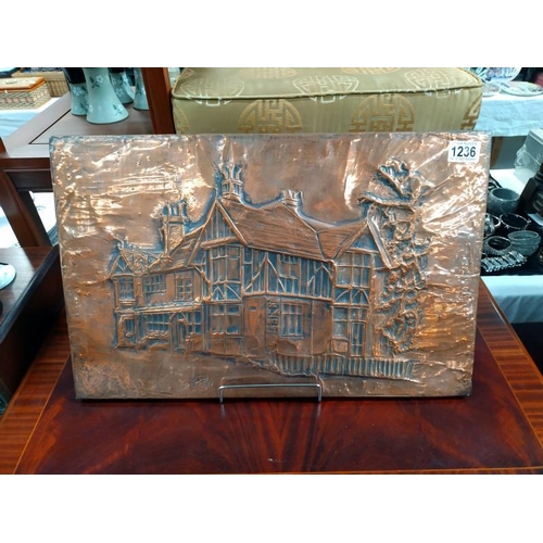 1236 - A worked Copper wall plaque of a Tudor house signed indistinct 79. 55cm x 36cm.