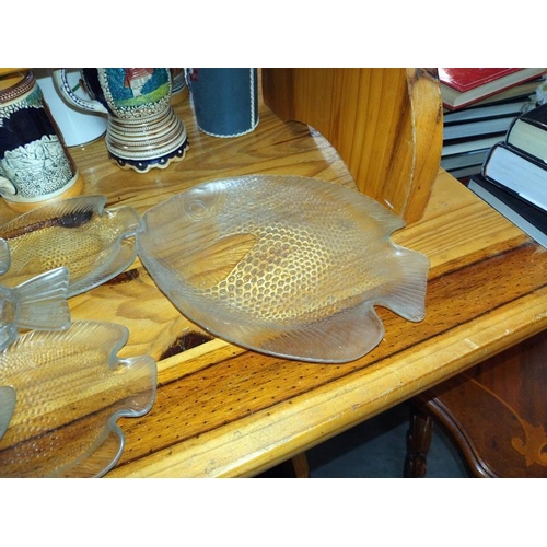 402 - A quantity of glass fish shape plates including one plastic. COLLECT ONLY.