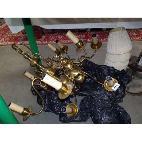 411 - Two, Five arm brass chandeliers with shades and a carved wooden arm ceiling light. COLLECT ONLY.