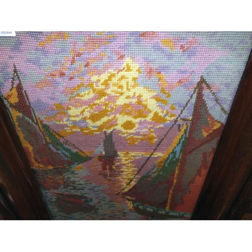 1419 - A mahogany fire screen with glazed woolwork of sailing boats in the sunset. 57cm x 58cm