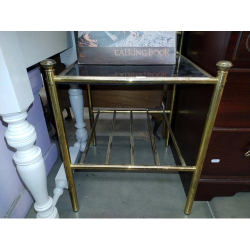 1438 - A brass framed coffee table with smoke glass. Top 42cm x 42, shelf height 49cm. COLLECT ONLY.