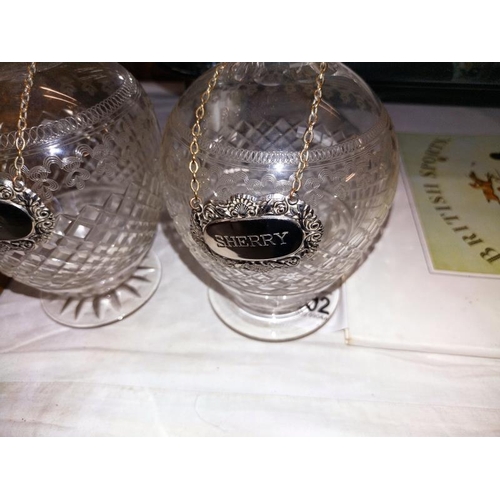 1507 - A pair of cut glass decanters, one stopper has chips to the bottom. With Sherry and Port labels. Hei... 