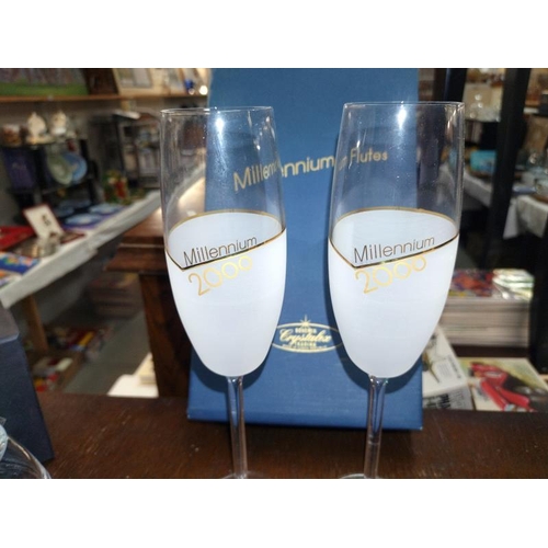 1522 - A boxed pair of Millenium flute glasses and a pair of Queens Diamond Jubilee candle holders.