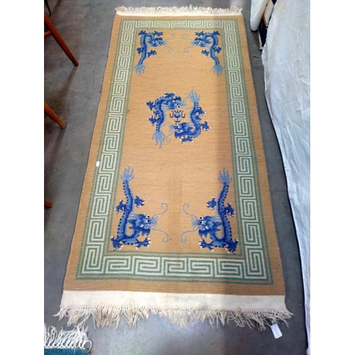 1525 - A beige and green rug with Blue dragon motifs. 172 cm x 78cm