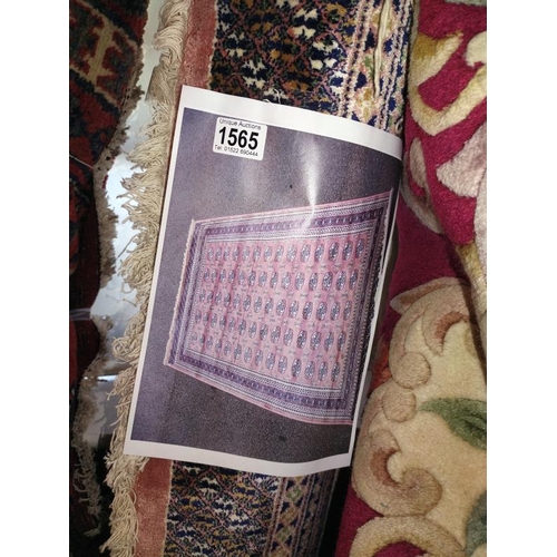 1565 - A pink patterned Persian style rug. Length 240cm x 170cm. COLLECT ONLY.