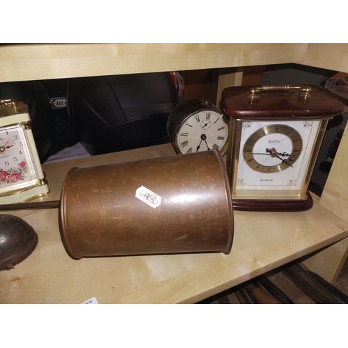 113 - A shelf on mantel clocks and copper ware.