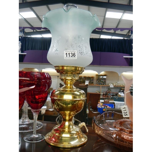 1136 - A brass oil lamp with green tinted tulip shade