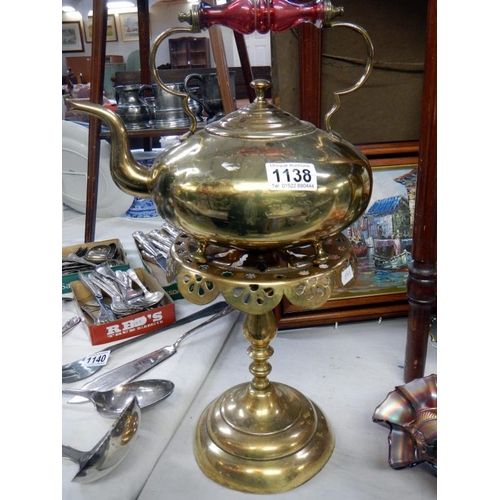 1138 - An early 20th century brass kettle on stand with cranberry glass handle