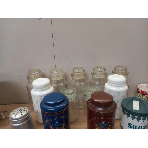 81 - A selection of glass, plastic and metal storage jars and a flour sifter