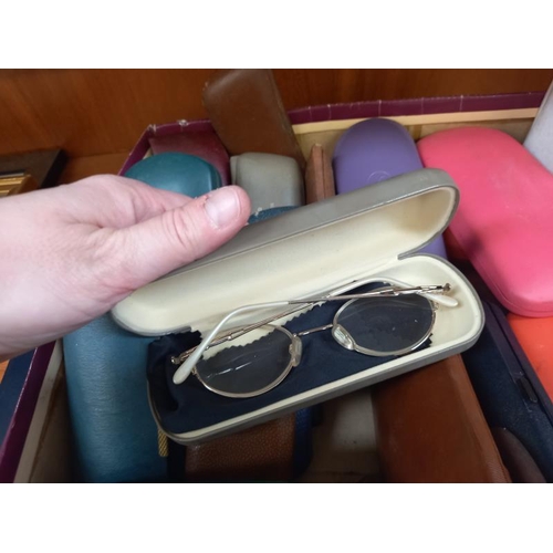 89 - A box of spectacle cases including some with glasses