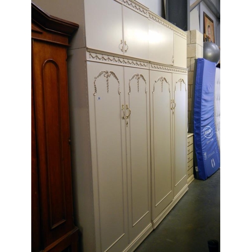 250 - A pair of modern double door wardrobes with floral relief decoration & over cabinets plus a bedside ... 