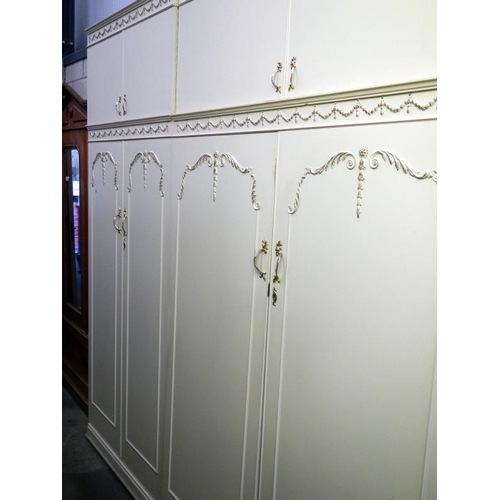 250 - A pair of modern double door wardrobes with floral relief decoration & over cabinets plus a bedside ... 