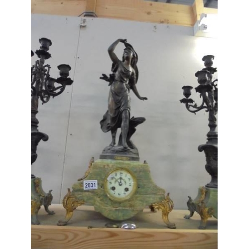 2031 - A Three piece French clock garniture - The clock with enamel dial and surmounted figure, (one candel... 