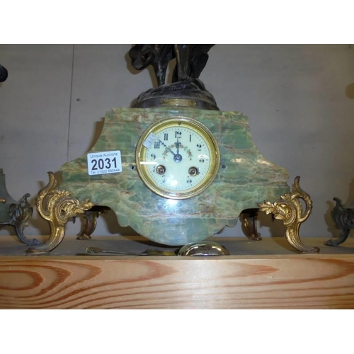 2031 - A Three piece French clock garniture - The clock with enamel dial and surmounted figure, (one candel... 