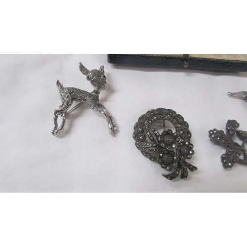 2090 - A silver bracelet, two silver marcasite brooches and three other brooches.