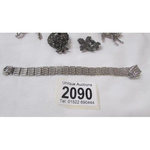 2090 - A silver bracelet, two silver marcasite brooches and three other brooches.