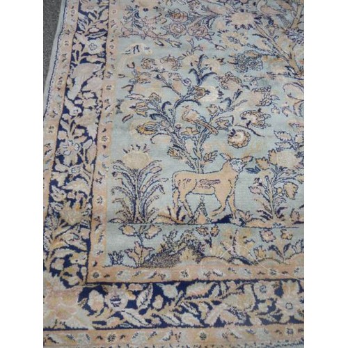 2197 - A green patterned rug depicting animals.