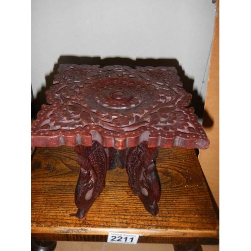 2211 - An early 20th century wooden stool and a miniature carved table.